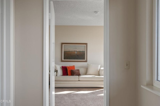 hall featuring a textured ceiling and carpet