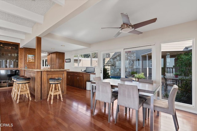 dining area featuring beam ceiling, a textured ceiling, hardwood / wood-style floors, and a ceiling fan