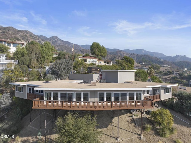 rear view of property featuring a deck with mountain view