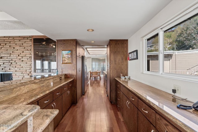 bar with a wealth of natural light, wood finished floors, and freestanding refrigerator