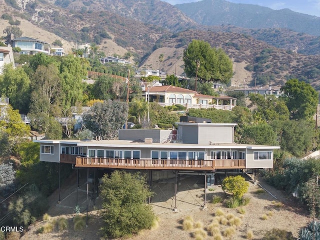 back of property with a deck with mountain view