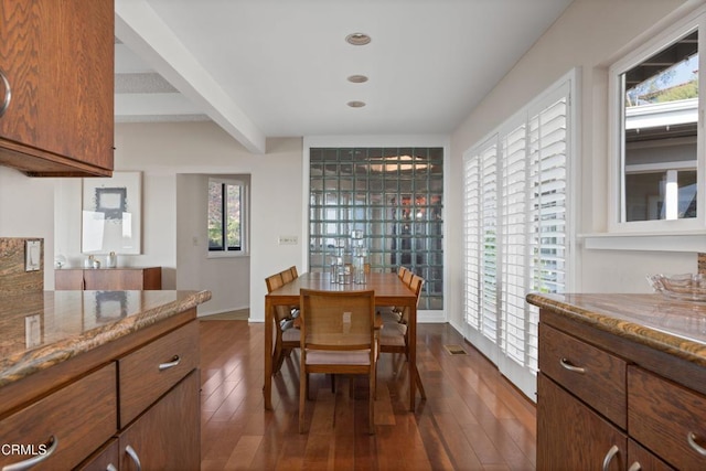 dining room featuring dark wood-style floors, beamed ceiling, and visible vents