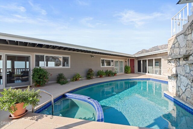 view of pool featuring a patio and a pool with connected hot tub