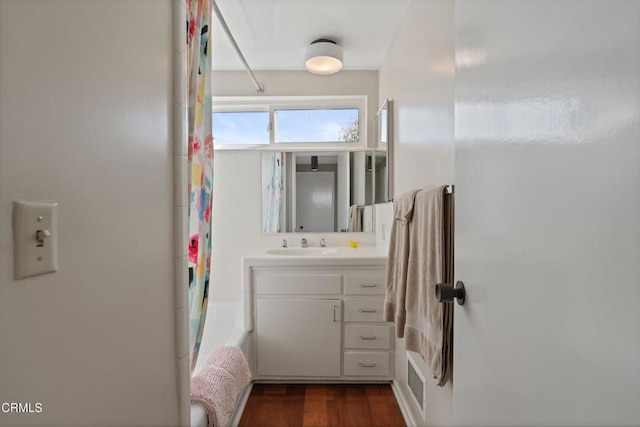 bathroom featuring vanity, shower / tub combo with curtain, and wood finished floors