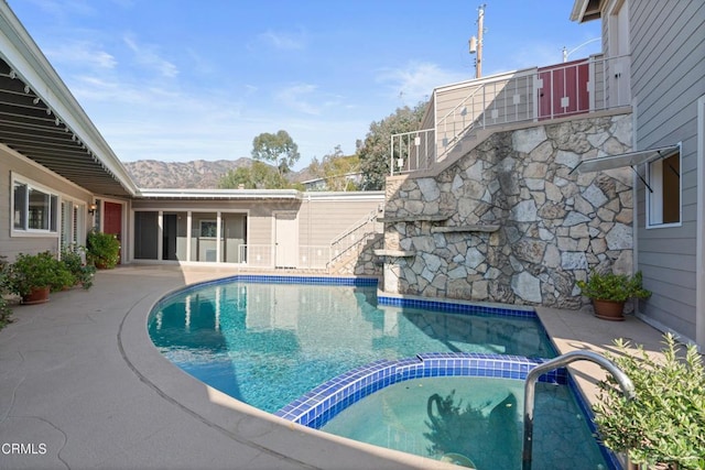 view of pool with a patio, stairway, a mountain view, and a pool with connected hot tub