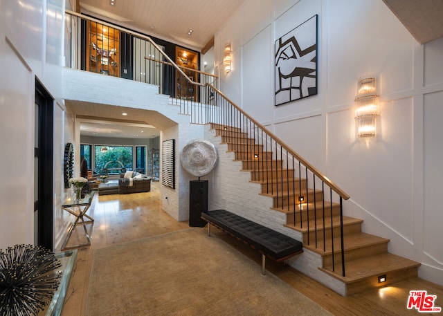 stairway featuring a towering ceiling and hardwood / wood-style floors