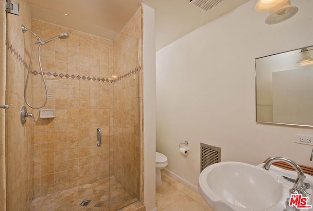 bathroom with tile patterned flooring, sink, a shower with shower door, and toilet