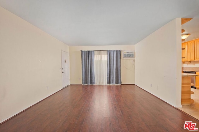 empty room with a wall mounted air conditioner and dark hardwood / wood-style flooring