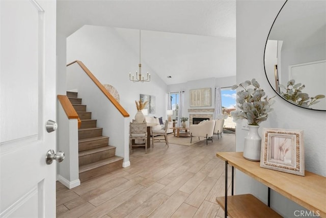 foyer featuring vaulted ceiling, an inviting chandelier, and light hardwood / wood-style floors