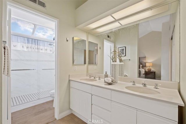 bathroom featuring vanity, a shower, hardwood / wood-style floors, and toilet