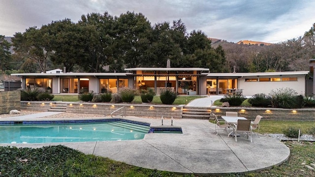 rear view of house featuring a mountain view and a patio area