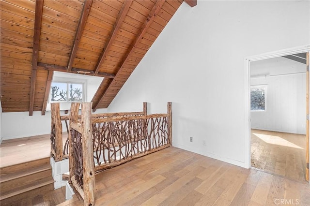 bonus room with lofted ceiling with beams, wood ceiling, and light hardwood / wood-style flooring