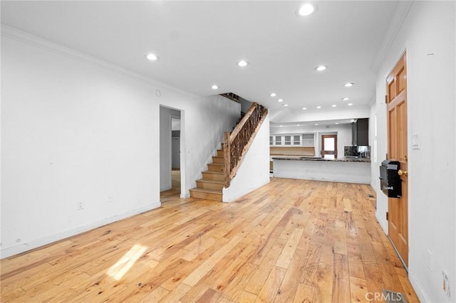 unfurnished living room with crown molding and light hardwood / wood-style floors