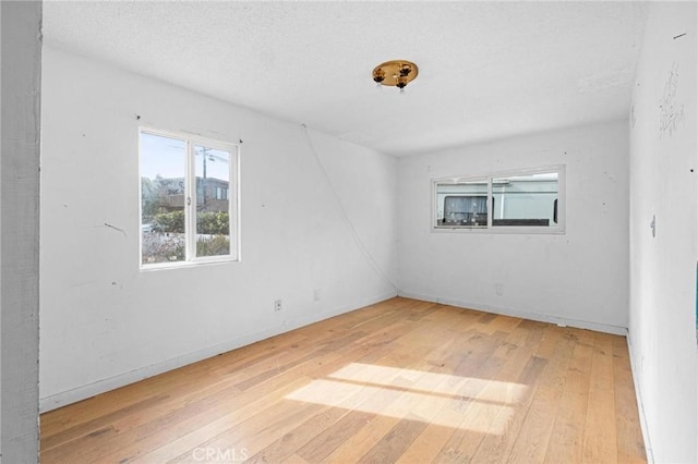 spare room featuring hardwood / wood-style floors and a textured ceiling