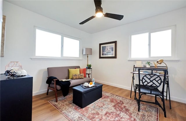 living area featuring hardwood / wood-style floors and ceiling fan