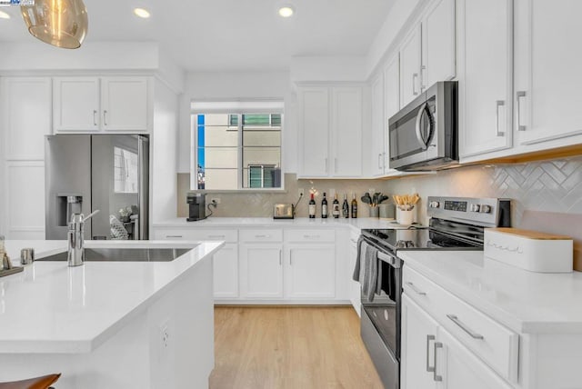 kitchen with white cabinetry, sink, tasteful backsplash, and stainless steel appliances