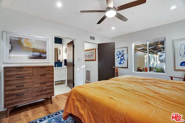 bedroom with light wood-type flooring, ceiling fan, and ensuite bathroom