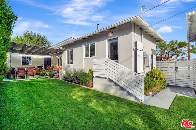 back of property featuring a lawn and a pergola