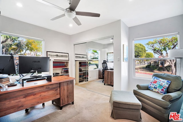 office space featuring light carpet, plenty of natural light, and ceiling fan