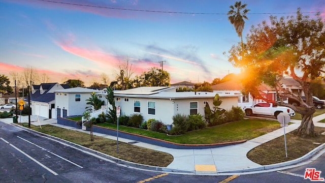 view of front of home featuring a yard and solar panels