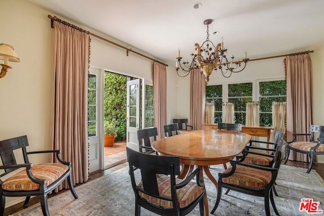 dining space with an inviting chandelier and light hardwood / wood-style flooring