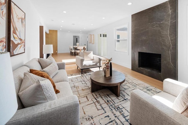 living room with a fireplace and light wood-type flooring