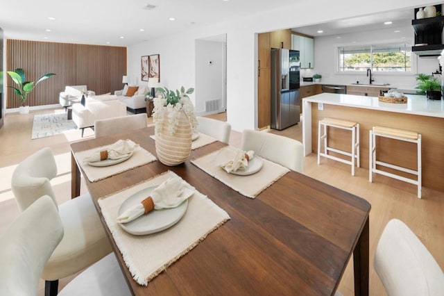 dining room featuring sink and light hardwood / wood-style floors