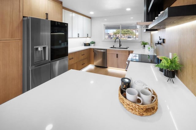 kitchen with white cabinetry, sink, ventilation hood, and appliances with stainless steel finishes