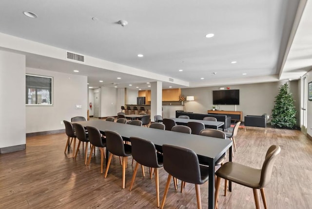 dining room with wood-type flooring and a tray ceiling