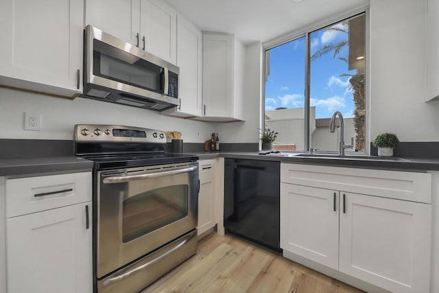 kitchen with white cabinetry, appliances with stainless steel finishes, and light hardwood / wood-style floors