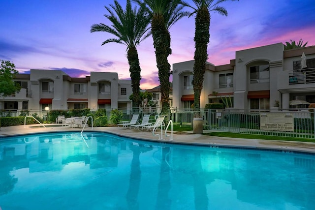 pool at dusk featuring a patio area