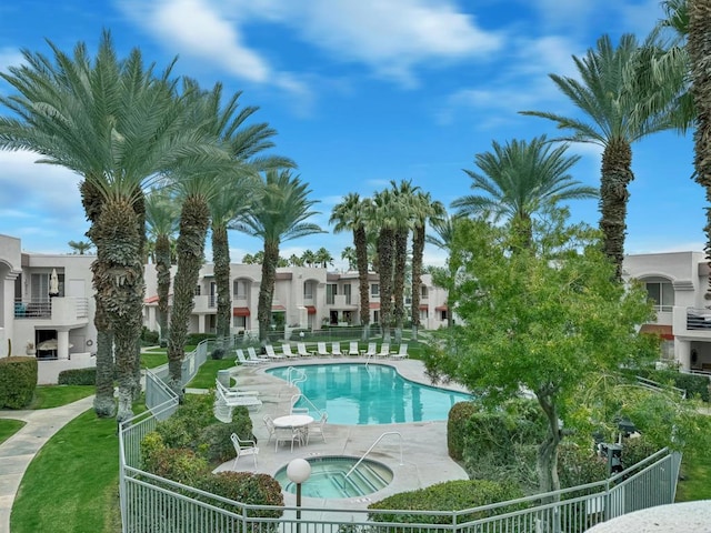 view of swimming pool featuring a community hot tub and a patio area