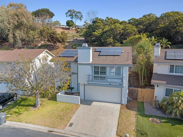 view of property featuring a balcony, a front lawn, and solar panels