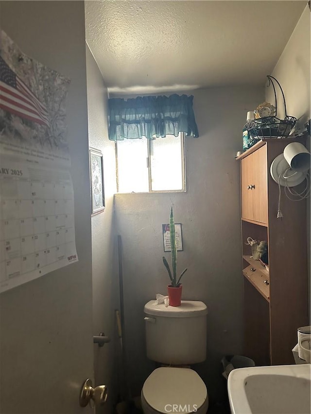 bathroom with toilet and a textured ceiling