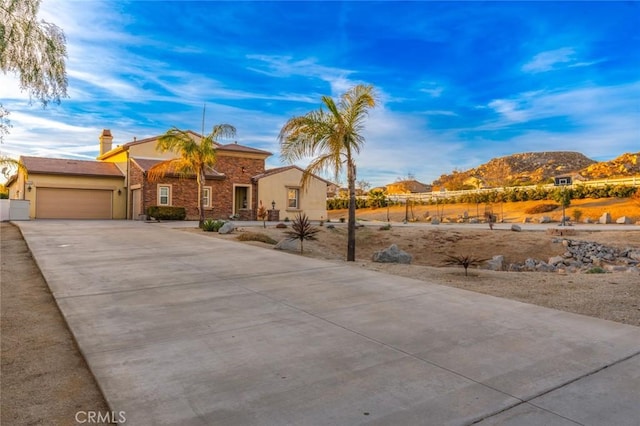 view of front of home featuring stucco siding, a mountain view, an attached garage, and concrete driveway