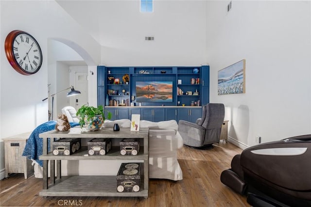 interior space featuring baseboards, dark wood-style floors, visible vents, and arched walkways