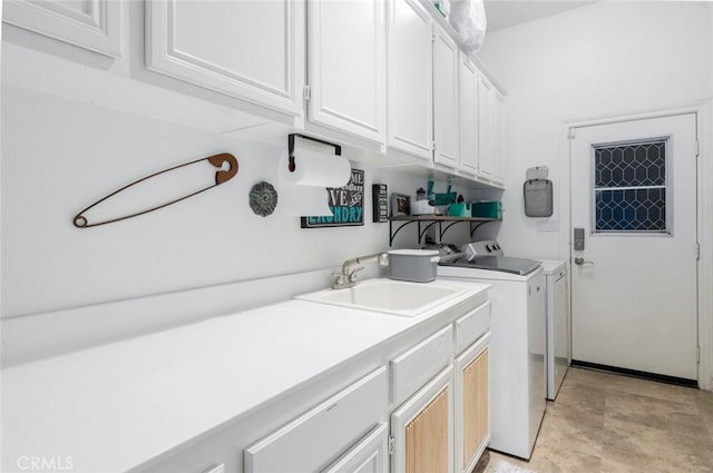 laundry area featuring washer and clothes dryer, cabinet space, and a sink