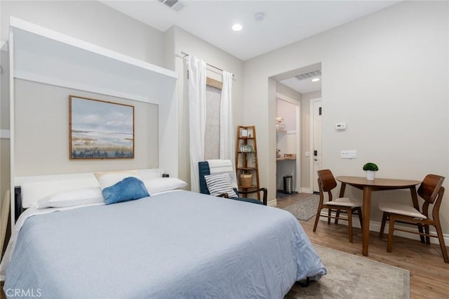 bedroom featuring baseboards, visible vents, recessed lighting, and wood finished floors