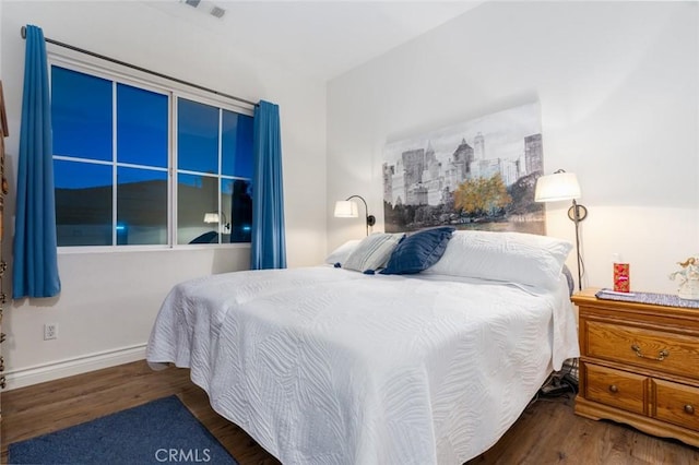 bedroom with baseboards, visible vents, and dark wood-type flooring