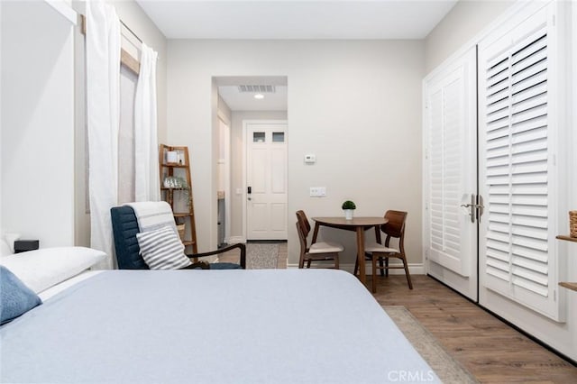 bedroom with visible vents, baseboards, and wood finished floors