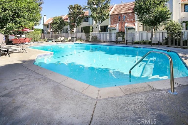 pool featuring a patio, fence, and a residential view
