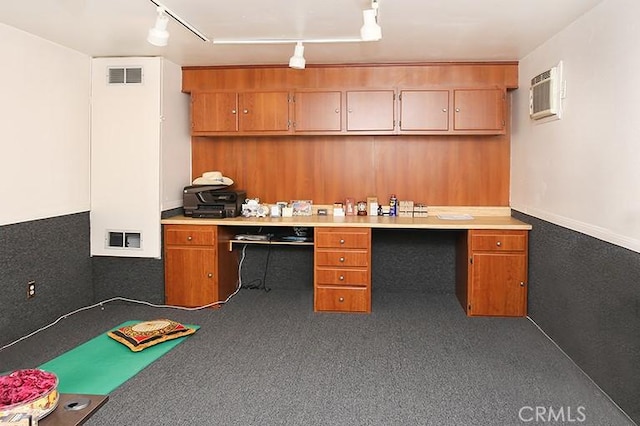 kitchen with carpet floors, built in desk, a wall unit AC, and rail lighting