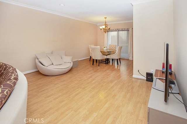 living room featuring crown molding, a notable chandelier, and light hardwood / wood-style floors