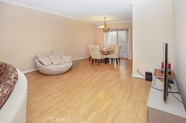 dining room with baseboards, a chandelier, ornamental molding, and light wood finished floors