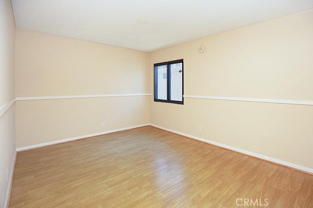 empty room with baseboards and wood finished floors