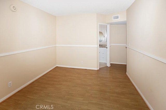 unfurnished room with hardwood / wood-style flooring