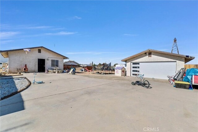 exterior space featuring a garage, an outdoor structure, and a trampoline