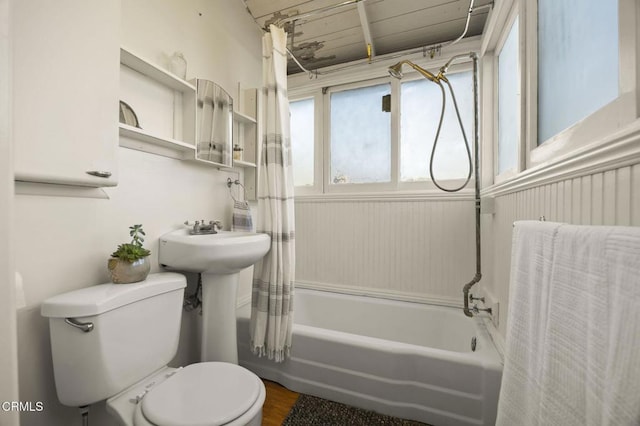 bathroom featuring shower / tub combo with curtain, hardwood / wood-style floors, and toilet