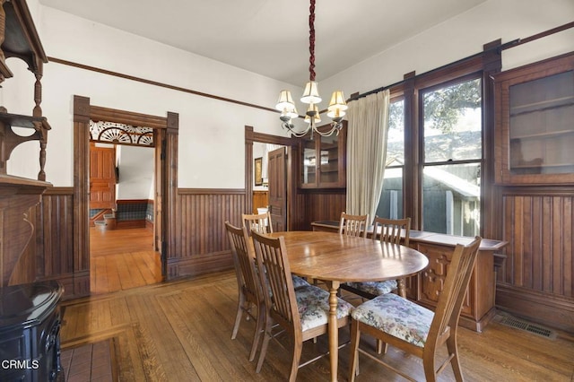 dining space with hardwood / wood-style flooring and a notable chandelier