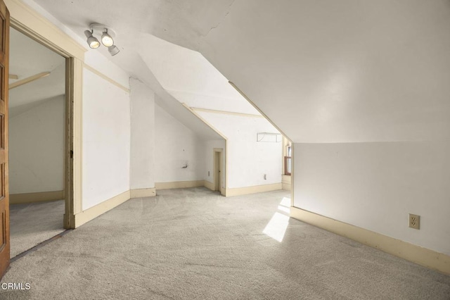 bonus room with light carpet and vaulted ceiling